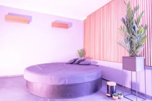 Image du fauteuil rond éclairé par une lampe mauve