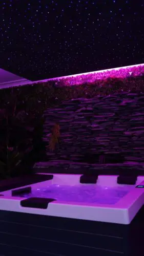 Image du jacuzzi sous néon rose avec un ciel etoilé