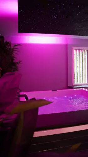 Image du jacuzzi sous néon rose avec un ciel etoilé